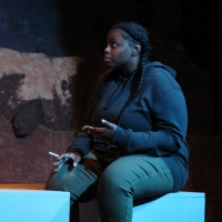 A woman sitting on a bench smoking a cigarette